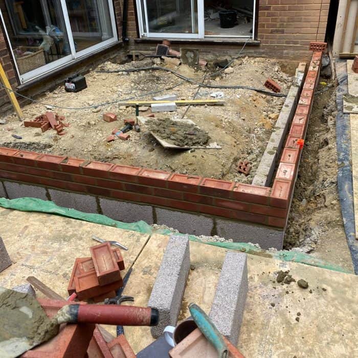 A house is being built by builders with bricks.