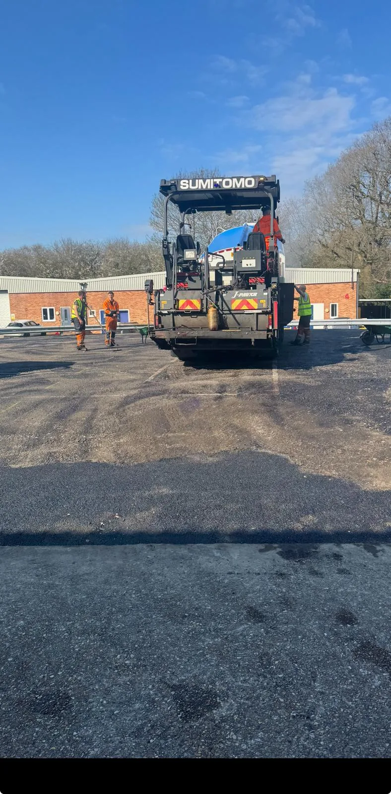 Asphalt paving machine laying a new commercial car park surface