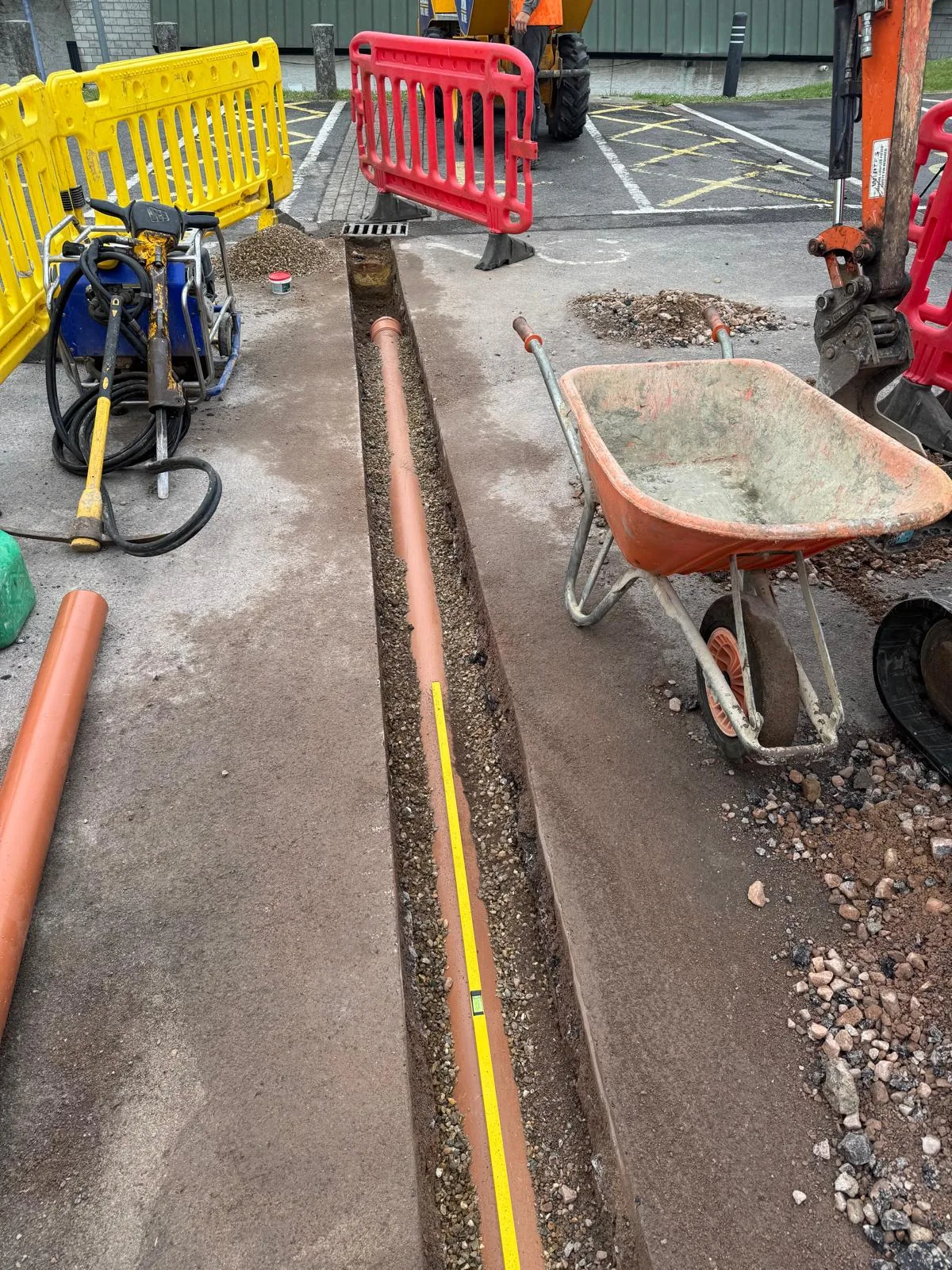 New drainage pipe installed to line and level in an excavated Surrey pavement